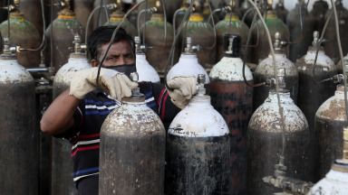 Covid_19, Indien, Arbeiter beim Nachfüllen von medizinischen Sauerstoffflaschen